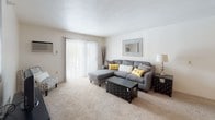 This single-floor residence at 1279 Kuder Ln in Warsaw, Indiana, offers a well-organized layout designed for comfortable everyday living. The living room is a welcoming space with plush carpeting, a sliding glass door fitted with vertical blinds that invites natural light and provides access to the outdoors, and a wall-mounted air conditioning unit for year-round comfort.

Adjacent to the living room, the dining area features a ceiling fan with a light fixture and connects seamlessly to the kitchen via a pass-through counter with under-cabinet lighting. The galley-style kitchen is efficiently arranged with ample white cabinetry accented by wood trim, a double-basin sink, and wood-look flooring that adds warmth to the space.

The unit includes multiple bedrooms, each finished with soft carpeting and windows that bring in natural light. The primary bedroom is equipped with a ceiling fan, while another bedroom features bifold closet doors offering generous storage. A full bathroom with wood-look flooring, a tub and shower combination, and vanity storage serves the unit conveniently. The neutral color palette and consistent finishes throughout create a cohesive and functional living environment.