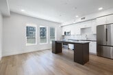 This well-designed studio in Meridian, Idaho offers a smart and functional layout across a single floor, making efficient use of every square foot. The open-concept living and kitchen area serves as the heart of the unit, featuring light hardwood-style flooring that flows throughout the space, creating a warm and cohesive aesthetic. The modern kitchen is outfitted with stainless steel appliances including a Bosch range, built-in microwave, dishwasher, and refrigerator, complemented by sleek white cabinetry, a subway tile backsplash, dark countertops, and a central island with pendant lighting — ideal for both cooking and casual dining. Large windows invite natural light and offer views of the surrounding neighborhood. The bedroom provides a comfortable, private retreat with clean white walls, a sliding double-door closet, and the same warm flooring. The bathroom is finished with a frameless glass walk-in shower, crisp white tile surround, recessed lighting, and an adjacent built-in shelving unit for added storage. A hallway connects the rooms seamlessly, contributing to the unit's organized flow. Throughout, the design maintains a clean, contemporary character with neutral tones and quality finishes.