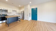 This 510 square foot apartment offers a thoughtful layout that maximizes space efficiency. The single-floor dwelling comprises one bedroom, measuring 110 square feet, and two bathrooms, providing ample personal space. The modern kitchen is a standout feature, boasting white cabinetry, stainless steel appliances, and a subway tile backsplash. A butcher block island adds functionality and warmth to the space.

Throughout the apartment, hardwood flooring creates a cohesive look, while carpeting in the bedroom adds comfort. The living area, though compact, feels open and airy due to its connection with the kitchen. A unique blue entry door adds a pop of color to the otherwise neutral palette.

Storage solutions are integrated throughout, including built-in shelving and closet space. The bathroom features a clean, white design with a shower/tub combination. Large windows in the bedroom offer natural light and potential views.

Despite its modest size, this apartment efficiently accommodates all essential living spaces, making it an ideal option for those seeking a well-designed, low-maintenance home in an urban setting.