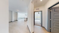 Located in Apollo Beach, FL, this single-story, 3-bedroom, 2-bathroom home offers a clean, contemporary design with an efficient and thoughtfully arranged floor plan. The open-concept living and kitchen area anchors the home, featuring light wood-style flooring, crisp white walls, and abundant natural light streaming through large windows with blinds. Built-in shelving adds functional character to the living space, which also includes a glass door providing outdoor access.

The kitchen is a standout, boasting two-tone cabinetry — white upper cabinets paired with dark lower cabinets — complemented by a white subway tile backsplash, quartz countertops, a center island with a sink, and stainless steel appliances including a refrigerator, range, and microwave.

The bedrooms are carpeted for comfort, each offering ceiling fans and natural light. The primary bedroom features its own closet access and a dedicated walk-in closet with wire shelving. The primary bathroom is well-appointed with a single-sink vanity featuring dark cabinetry, quartz countertops, a framed mirror, and a glass-enclosed walk-in shower with tile surround. A hallway connects the rooms, completing this modern and functional layout.