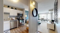 Located at 1180 Cushing Circle in Saint Paul, MN, this one-bedroom, one-bathroom residence offers a thoughtfully designed single-floor layout that maximizes every square foot. The kitchen is a standout, featuring stainless steel appliances — including a refrigerator, range, microwave, and dishwasher — white shaker-style cabinetry, granite-look countertops, and a gray subway tile backsplash, all set atop durable wood-look flooring. The open-concept living and dining area is bright and inviting, anchored by a bold teal accent wall and large windows that allow generous natural light to fill the space. The carpeted bedroom offers a comfortable retreat with a sizable closet equipped with built-in shelving and hanging rods, alongside an additional window with outdoor views. Two more closets provide abundant storage throughout the unit. The full bathroom includes a tub-shower combination with clean, classic finishes. A dedicated laundry area adds everyday convenience. A hallway connects the rooms with ease, creating a cohesive and functional flow throughout this well-designed Saint Paul residence.