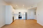 Located on Tenth St W in Bradenton, FL, this thoughtfully designed one-bedroom, one-bathroom residence offers a clean, modern aesthetic with a bright, open feel throughout. The combined kitchen and living area serves as the heart of the home, featuring light wood-style flooring that flows seamlessly through the space. The kitchen is well-equipped with white shaker-style cabinetry extending to the ceiling, granite countertops, a subway tile backsplash, and a full suite of stainless steel appliances including a refrigerator, range, microwave, and dishwasher. Recessed lighting illuminates the space efficiently. The open living area offers a generous, airy footprint with clean white walls and natural light from nearby windows. The bedroom is a comfortable retreat, featuring dual closets, a ceiling fan, and a large window with blinds that invite natural light. The bathroom is finished with elegant marble-look tile on both the floors and tub surround, complemented by a white vanity with a granite countertop. A hallway closet houses a stacked washer and dryer, adding in-unit laundry convenience. The overall design is cohesive and contemporary, making efficient use of every square foot.