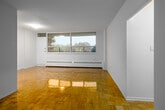 Located at 2560 Kensington Rd in Toronto, this 2-bedroom, 1-bathroom unit offers a practical and well-laid-out single-floor living space. Classic parquet flooring runs throughout the unit, lending warmth and a timeless character to every room.

The living room is a bright, open area with access to the adjacent galley-style kitchen, which features white cabinetry, granite-look countertops, a stainless steel sink, and tile flooring. A in-unit laundry area adds everyday convenience.

The primary bedroom is a comfortable, well-proportioned room with large windows that allow natural light and views of the surrounding neighbourhood. It includes a double closet with gold-toned hardware. The second bedroom is similarly sized, with its own window and a built-in closet, making it well-suited as a guest room, nursery, or home office.

The bathroom is finished with mosaic tile flooring, a full bathtub, and a marble-topped vanity, complemented by a small window that brings in natural light. A dedicated entrance and hallway provide a smooth transition into the main living areas.

Throughout the unit, the clean white walls and consistent parquet flooring create a cohesive, neutral aesthetic that is easy to personalize.