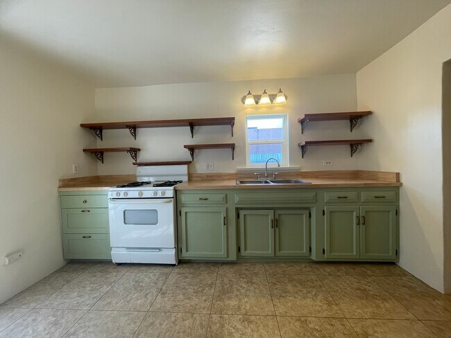 Remodeled kitchen with butcher-block countertop and custom-built shelves - 519 N Melrose Ave