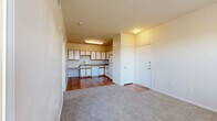 Located in San Antonio, TX, this one-bedroom, one-bathroom unit offers a practical and well-organized single-floor layout. The open living area features neutral-toned carpet, a ceiling fan, and a large window alongside a glass-panel door that leads out to a private balcony, filling the space with natural light and outdoor views. The kitchen is equipped with warm hardwood flooring, ample white cabinetry with wood trim, a double sink, dishwasher, and a white range — providing all the essentials for everyday cooking. The bedroom is a comfortable, carpeted retreat featuring two windows that invite natural light and greenery views, along with a ceiling fan for added comfort. The full bathroom includes a wide vanity with wood-accented cabinetry, a large mirror, tiled shower/tub combo, and direct access to a walk-in closet with built-in shelving. A second closet provides additional storage. An in-unit laundry area adds convenience to daily routines. Throughout the unit, a consistent neutral color palette, clean white trim, and a mix of hardwood and carpet flooring create a cohesive and functional living environment.