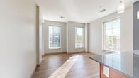 Located at 198 S High St in downtown Columbus, Ohio, this one-bedroom, one-bathroom unit offers a well-designed layout with modern finishes throughout. Light hardwood-style flooring flows through the main living areas, complemented by neutral walls and abundant natural light from multiple windows fitted with blinds.

The open-concept kitchen and living area serves as the heart of the unit. The kitchen is well-appointed with rich cherry wood cabinetry, dark granite countertops, a central island with pendant lighting, stainless steel appliances including a refrigerator, range, and microwave, and a track lighting system overhead. The living area features multiple tall windows that invite generous natural light and views of the surrounding cityscape.

A bright hallway connects all rooms, leading to the carpeted bedroom, which includes a sliding glass door opening to one of two private balconies with views of the Columbus skyline. The full bathroom features hardwood-style flooring, a wood vanity with granite countertop, and clean white fixtures. The dedicated laundry room includes a washer and dryer with overhead wire shelving for storage. A utility room and entrance area complete the functional layout of this efficiently designed urban residence.