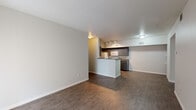 This single-floor unit offers a practical and well-organized layout designed for comfortable everyday living. The open-concept living area flows seamlessly toward the kitchen, connected by a peninsula counter that defines the two spaces while maintaining an airy, connected feel. Durable wood-look flooring runs throughout the main living and kitchen areas, providing a clean and cohesive aesthetic.

The galley-style kitchen is thoughtfully appointed with dark cabinetry, dark granite-style countertops, and white appliances including a refrigerator, electric range, microwave, and dishwasher. Track lighting illuminates the workspace, and ample upper and lower cabinet storage makes the kitchen highly functional. A window at the end of the kitchen corridor allows natural light to filter in.

The bedroom features neutral-toned walls, plush wall-to-wall carpeting, and a closet, offering a quiet and comfortable retreat. The bathroom is clean and straightforward, finished with wood-look flooring and a full tub and shower combination with white tile surround and chrome fixtures.

Throughout the unit, a neutral color palette of whites, grays, and warm tones creates a calm and versatile backdrop, making it easy to personalize the space to suit a variety of styles.