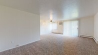 Located at 23691 Delmere Dr in North Olmsted, Ohio, this single-floor unit offers a practical and comfortable layout designed for everyday living. The generous living area is finished with neutral wall-to-wall carpeting and features a ceiling fan with light fixture, a baseboard heating unit, a wall-mounted air conditioner, and sliding glass doors dressed with vertical blinds that allow for ample natural light. The space has a clean, open feel with white walls and a textured ceiling throughout.

The galley-style kitchen is well-appointed with warm cherry-toned cabinetry, granite-look countertops, and wood-look vinyl flooring. It includes white appliances — a range, refrigerator, and dishwasher — along with a sink, offering a functional cooking and prep environment.

The bedrooms are carpeted and bright, each benefiting from natural light through windows with views of the surrounding neighborhood. One bedroom includes a walk-in closet alongside an additional closet, providing generous storage. The full bathroom is finished with white tile surrounding the tub/shower combination, complemented by wood-look vinyl flooring, a vanity with cabinetry, and clean, simple fixtures. The entry area features tile flooring, providing a practical transition space into the carpeted living areas.