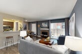 Located at 9940 Richmond Ave in Houston, TX, this single-floor, 2-bedroom, 2-bathroom home offers a thoughtfully designed layout with modern finishes and a cohesive color palette anchored by bold blue accent walls. The living room serves as the heart of the home, featuring a classic brick fireplace, wood-look flooring, and large sliding glass doors that invite natural light and provide access to an outdoor area. An adjacent dining space offers an intimate setting with chair-rail molding detail and easy flow to the kitchen pass-through. Both bedrooms are carpeted and feature the signature blue accent walls, ceiling fans, and ample natural light from large windows. The generously sized primary bedroom includes a walk-in closet outfitted with built-in shelving and hanging rods for well-organized storage. The second bedroom is equally comfortable, with mirrored side tables and stylish décor. Each bathroom is finished with wood-look flooring, a tub-shower combo, and dark vanity cabinetry with light countertops. A dedicated in-unit laundry closet houses a full-size washer and dryer with overhead shelving. Three closets throughout provide excellent storage. The hallway connects all areas seamlessly, making this a highly functional and attractively styled home.