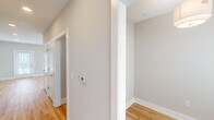 Located in Kernersville, NC, this well-appointed 1-bedroom, 1-bathroom home offers a clean, modern design across a single thoughtfully laid-out floor. The open-concept kitchen and living area serves as the heart of the home, featuring warm light hardwood flooring, soft neutral walls, and a ceiling fan that enhances airflow throughout the space. The kitchen is equipped with crisp white shaker-style cabinetry extending to the ceiling for ample storage, a white subway tile backsplash, stainless steel appliances including a refrigerator, electric range, microwave, and dishwasher, and recessed lighting overhead. The spacious bedroom offers plush carpeting, multiple windows with blinds that invite natural light, and a ceiling fan. The bathroom includes a full tub-shower combination with brushed nickel fixtures and a curved shower rod. The hallway connecting the rooms features vaulted-style angled ceilings, adding architectural interest, along with light hardwood floors, clean white trim, and a programmable thermostat. A dedicated closet and entrance round out the functional layout, making this home a practical and inviting residence in a quiet Kernersville neighborhood.