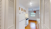 Located at 5747 N Winthrop Ave in Chicago's Edgewater neighborhood, this single-floor unit offers a well-organized layout with a clean, bright aesthetic throughout. Warm hardwood floors extend across the main living spaces, reflecting natural light that pours in through multiple windows overlooking lush greenery outside.

The living area is generously proportioned, featuring white walls, large windows with tree-lined views, and baseboard heating. Its open sightline to the kitchen creates a connected, functional flow. The galley-style kitchen is efficiently designed, featuring white cabinetry with wood-toned accents, a gas range, full-size refrigerator, and a sink with under-counter storage — all illuminated by track lighting above. A decorative pendant light marks the transition toward the dining area, which benefits from a window framing outdoor greenery.

The bedroom provides a comfortable retreat with a dedicated closet fitted with built-in shelving, a window with blinds for privacy, and the same rich hardwood flooring found throughout. Baseboard heating ensures year-round comfort.

The bathroom is finished with classic white tile flooring, a full tub-shower combination, a vanity with under-sink storage, and clean white walls — offering a simple, functional design. The unit's consistent use of light tones and natural wood flooring gives it a cohesive, welcoming character throughout.