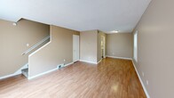 Located at 3610 Spottswood Avenue in Memphis, Tennessee, this two-story, one-bedroom, one-bathroom home offers a practical and comfortable layout spread across two well-proportioned floors. The main level features a bright, open living room with warm hardwood-style flooring, neutral tan walls, a textured ceiling, and a sliding glass door that fills the space with natural light and provides outdoor access. Adjacent to the living area, the kitchen is outfitted with white cabinetry, white appliances including a stovetop range, and tile flooring, with a dedicated space accommodating in-unit laundry. A staircase leads to the upper level, where the generously sized primary bedroom impresses with plush wall-to-wall carpeting, a textured ceiling, multiple windows that invite natural light, and two closets offering ample storage. The full bathroom on the upper level includes a tub-shower combination with built-in shelving and a curtain rod, finished in a clean white surround. Throughout the home, consistent warm neutral tones create a cohesive and inviting ambiance, while the two-story design provides a clear separation between the living and sleeping areas, enhancing both privacy and functionality.