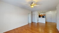 Located at 1010 Central Ave in Indianapolis, Indiana, this single-floor, 2-bedroom, 2-bathroom residence offers a practical and well-organized layout. The open-concept kitchen and living area serves as the heart of the home, featuring warm hardwood-style flooring, a ceiling fan with light fixture, and a peninsula with light countertops that doubles as a breakfast bar. The kitchen is equipped with wood-toned cabinetry, black appliances including a refrigerator, range, and microwave, and a double-basin sink. Elegant pendant lighting hangs above the peninsula, adding a polished touch to the space. A door provides access to natural light from outside. The primary bedroom is a generously sized retreat with hardwood-style flooring, a ceiling fan, and access to a walk-in closet outfitted with wire shelving for ample storage. The second bedroom features plush carpeting and a window with an outdoor view. Both bathrooms include wood-toned vanities, matching countertops, and a tub/shower combination. The unit also includes a library and a utility room, and boasts an impressive total of six closets throughout, ensuring abundant storage. The clean, neutral color palette and consistent finishes create a cohesive and functional living environment.