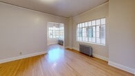 Located at 1431 SW Park Ave in Portland, Oregon, this one-bedroom, one-bathroom unit offers a thoughtfully laid-out floor plan that includes a living room, dining room, kitchen, bedroom, hallway, and three closets. The space is characterized by warm hardwood floors that flow consistently throughout, complementing the clean white walls and classic architectural trim work.

The living and dining areas are bright and open, benefiting from large multi-pane windows that invite natural light deep into the rooms. Vintage cast-iron radiators add a charming period detail while providing efficient heating. The kitchen stands out with its striking black-and-white checkered tile floor, white cabinetry with leaded glass accents, stainless steel appliances, and generous built-in storage reaching to the ceiling.

The bedroom is a comfortable and well-proportioned retreat, featuring its own window with a cast-iron radiator beneath it and access to multiple closets, offering practical storage solutions. The bathroom maintains the classic aesthetic with crisp white subway tile surrounding the tub-shower combination, black-and-white floor tile, and chrome fixtures, including safety grab bars. Throughout the unit, the cohesive neutral palette and consistent hardwood flooring create a warm, unified ambiance rooted in timeless design.
