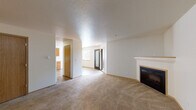 Located at 2948 W Powell Blvd in Gresham, Oregon, this single-floor unit offers a well-organized layout designed for comfortable everyday living. The open living area is finished with plush wall-to-wall carpeting and features a classic fireplace with a white mantle, serving as the room's focal point. A glass-panel entry door allows natural light to filter into the space, enhancing its bright and welcoming ambiance. Textured ceilings are consistent throughout the unit, adding a layer of visual detail overhead.

The kitchen is outfitted with warm honey-toned wood cabinetry providing ample storage, light-colored countertops, and tile flooring. White appliances include an electric range, dishwasher, and refrigerator, all neatly integrated into the L-shaped layout with an overhead range hood.

Multiple carpeted bedrooms each feature windows with views of surrounding greenery, offering a quiet and private feel. The neutral wall tones and soft carpeting create a calm atmosphere throughout.

Two full bathrooms are finished with matching tile flooring and warm wood vanities. Each includes a tub-shower combination and a wide mirror above the single-sink vanity. The consistent design language across both bathrooms contributes to a cohesive interior aesthetic throughout the home.