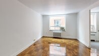 Located at 1065 Eglinton Ave W in Toronto's vibrant Midtown neighbourhood, this 2-bedroom, 1-bathroom unit offers a practical and well-appointed layout across a single floor. Warm parquet flooring runs throughout the living areas and bedrooms, lending a classic character to the space. A charming arched hallway connects the main living area to the rest of the unit, adding an architectural detail that stands out.

The living room is a bright, open space with clean white walls and polished parquet floors, receiving natural light through a large window with a radiator unit below. The two bedrooms are modestly sized with the same parquet flooring and white walls, each featuring windows that bring in natural light and radiator heating.

The kitchen is updated with white cabinetry, a subway tile backsplash, dark countertops, a stainless steel appliance, and grey tile flooring. A large window above the radiator provides natural light and ventilation.

The bathroom has been renovated with full white subway tile walls, a tub-shower combination, a modern vanity with a stone-look countertop, and a frosted privacy window. Two hallways provide functional circulation throughout the unit, keeping the layout organized and efficient.
