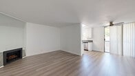 Located in the heart of Hollywood at 1321 N Las Palmas Ave, this 2-bedroom, 1-bathroom residence offers a clean, modern aesthetic throughout its single-floor layout. Light wood-style flooring runs continuously through every room, creating a cohesive and airy feel. The open living area is bright and inviting, anchored by a fireplace and sliding glass doors that lead to an outdoor space, filling the room with natural light. A ceiling fan adds functional comfort to the living space. The galley-style kitchen is well-appointed with white shaker cabinetry, dark countertops, stainless steel appliances including a gas range and dishwasher, and a window that brings in additional natural light. A central hallway connects the bedrooms and bathroom, maintaining a logical and efficient flow. The primary bedroom is generously sized, featuring a window with greenery views, while the second bedroom includes mirrored sliding closet doors. The shared bathroom is cleanly finished with white cabinetry, a single-sink vanity with a large mirror, and a shower-tub combination with white tile surround. Throughout, the crisp white walls and consistent finishes create a bright, move-in ready environment in a prime Los Angeles location.