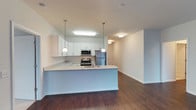 This Colonial-style residence offers a thoughtfully designed single-floor layout with two bedrooms and two full bathrooms. The interior features warm hardwood flooring that flows throughout the living areas, creating a cohesive and inviting atmosphere. Neutral-toned walls provide a versatile backdrop suited to a variety of décor styles. The main living area is highlighted by a large sliding glass door dressed with vertical blinds, opening to a private balcony that brings in generous natural light and offers pleasant outdoor views of the surrounding landscape, including mature trees. The clean, open layout provides a comfortable sense of space, and the central HVAC system with ceiling vents ensures year-round climate comfort. The two well-proportioned bedrooms offer restful retreats, while the two full bathrooms add everyday convenience. The Colonial architectural influence is evident in the structured, balanced design of the floor plan. This residence combines functional living spaces with classic styling, making it a practical and comfortable home with both interior warmth and a connection to the outdoors through its light-filled living areas.