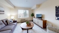 This 560 square foot apartment in Gresham, Oregon, offers a thoughtful layout maximizing space and functionality. The single-floor dwelling comprises one bedroom, one bathroom, a living room, kitchen, and hallway. The primary bedroom, measuring 170 square feet, provides ample space for relaxation and storage.

The kitchen showcases a modern design with white cabinetry, stainless steel appliances, and a functional layout. It features a full-size refrigerator, dishwasher, range, and over-the-range microwave, catering to all culinary needs. The living area, while compact, offers a comfortable space for lounging and entertaining, adorned with a stylish gray sofa and contemporary decor.

The bedroom boasts large windows allowing natural light to flood the space, complemented by soft, neutral tones and plush bedding. The bathroom, though not expansive, is efficiently designed with a shower/tub combination and modern fixtures.

Throughout the apartment, light wood-look flooring creates a sense of continuity and enhances the perception of space. Large windows in the living area and bedroom not only brighten the interior but also offer views of the surrounding area.

Despite its modest size, this apartment at 2752 NE Hogan Dr demonstrates clever use of space, modern amenities, and a fresh, contemporary aesthetic, making it an attractive option for those seeking comfortable living in a compact urban setting.