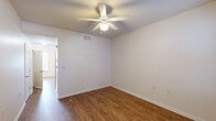 This two-story townhouse in New Orleans, Louisiana offers a practical and comfortable layout across two floors. The main level features a functional kitchen equipped with warm wood-toned cabinetry, dark countertops, a full suite of white appliances including a refrigerator, electric range, microwave, and dishwasher, all set atop durable wood-look flooring. A dedicated utility room on the main level houses an in-unit washer and dryer alongside a water heater, providing added convenience. Living areas on the main floor are brightened by natural light streaming through windows fitted with blinds, and a door opens directly to the exterior. Ceiling fans are present in multiple rooms, promoting airflow and comfort throughout. The upper level hosts two bedrooms, one with plush carpeting and a ceiling fan, and another with wood-look flooring and natural light from a window with blinds. The full bathroom features tile flooring, a vanity with ample counter space, and a tub-shower combination. A half bath provides additional convenience for guests. Neutral wall tones and clean finishes throughout the home create a simple, move-in ready atmosphere well-suited to the New Orleans lifestyle.