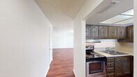 This 860 square foot apartment offers a thoughtful blend of comfort and functionality. The two-bedroom layout is ideal for various living arrangements, with the primary bedroom boasting a generous 160 square feet. Rich, warm-toned hardwood flooring flows throughout the space, creating a cohesive and inviting atmosphere.

The kitchen is equipped with modern stainless steel appliances, including a refrigerator and dishwasher. Wood cabinetry in a classic style provides ample storage, while the drop ceiling with recessed lighting adds a contemporary touch. A window allows natural light to brighten the cooking area.

The bathroom features a clean, neutral design with a tiled vanity countertop and large mirror, creating a sense of spaciousness. The living areas are bathed in natural light from large windows, some with horizontal blinds for privacy control. Multiple closets, including walk-in options, offer abundant storage solutions.

The apartment's layout is well-considered, with a central hallway connecting the various rooms. Textured ceilings throughout add visual interest, while the crisp white walls provide a blank canvas for personalization. This property combines practical amenities with a comfortable living environment, making it an attractive option for those seeking a modern, well-appointed home.