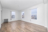 Located at 3333 W 4th St in the heart of Los Angeles, this 1-bedroom, 1-bathroom unit offers a well-organized, single-floor layout with a clean, modern aesthetic throughout. Light wood-tone flooring runs continuously across all rooms, complementing the crisp white walls and trim that give the space a bright, airy feel.

The living room is generously sized and bathed in natural light from multiple large windows, offering elevated views of the surrounding Los Angeles cityscape. An arched doorway connects the living area to the hallway, adding a subtle architectural charm. The bedroom is a comfortable size, featuring two dedicated closets for ample storage and windows that frame neighborhood rooftop views.

The galley-style kitchen is efficiently laid out with white shaker cabinetry, dark countertops, a double stainless steel sink, a gas range, and a refrigerator — all complemented by recessed lighting and a window that brings in additional natural light.

The bathroom features wood-look flooring, a full soaking tub, and elegant marble-style tile surround that extends to the ceiling, alongside a white vanity and a frosted window for natural light and privacy.

A hallway connects all rooms seamlessly, and includes a built-in arched niche that adds a classic architectural detail. The overall ambiance is clean, neutral, and move-in ready.