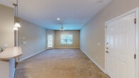 Located at 3300 Stadium Dr in Phenix City, Alabama, this single-story residence offers a practical and comfortable layout across a thoughtfully designed floor plan. The open-concept living, dining, and kitchen area forms the heart of the home, featuring warm neutral walls, plush wall-to-wall carpeting, and a ceiling fan with light fixture. Natural light filters in through a front-facing window with blinds and a side entry door, creating a bright and welcoming atmosphere.

The kitchen is efficiently designed with rich dark wood cabinetry, light-toned countertops, hardwood-style flooring, and black appliances including a range, microwave hood, and refrigerator. Adjacent to the kitchen, the bathroom is finished with matching hardwood-style flooring and includes in-unit washer/dryer hookups with a louvered closet door for added convenience.

The bedroom is a generously proportioned retreat, carpeted for comfort and fitted with a ceiling fan and light fixture. A large sliding glass door with vertical blinds opens to an outdoor view, filling the room with natural light. A dedicated closet provides ample storage. Throughout the residence, warm beige tones and clean white trim create a cohesive, move-in-ready aesthetic.