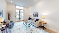 Located at 29 Burgess Ave in East Providence, Rhode Island, this single-floor unit showcases a clean, contemporary design throughout. Light-toned hardwood flooring and crisp white walls create a bright, cohesive aesthetic that flows seamlessly from room to room.

The kitchen is a standout feature, outfitted with tall white shaker-style cabinetry, granite countertops, stainless steel appliances, and a central island that provides additional prep space and casual seating. The open layout connects the kitchen naturally to the dining and living areas, promoting an easy, functional flow.

The living room is generously proportioned and filled with natural light, thanks to oversized windows and a glass sliding door that opens to a private balcony with neighborhood views. Recessed lighting complements the natural brightness throughout.

Both bedrooms are well-sized, featuring light-filled windows, recessed lighting, hardwood floors, and closet storage. The primary bedroom includes a spacious closet accessible through a paneled door. The full bathroom is finished with granite countertops, white cabinetry, and warm hardwood-style flooring, maintaining the unit's consistent design language.

A dedicated laundry area accommodates a full-size stacked washer and dryer alongside a compact granite-topped cabinet, adding practical convenience to the well-appointed space.