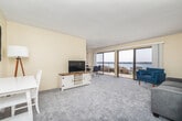 Located at 270 Portofino Way in Redondo Beach, CA, this one-bedroom, one-bathroom coastal unit offers an efficient and well-organized layout with direct waterfront views throughout. The combined living and dining area is the heart of the space, featuring plush carpeting, a textured ceiling, and a ceiling fan. Floor-to-ceiling sliding glass doors open to a private balcony overlooking the marina, flooding the interior with abundant natural light and providing unobstructed views of the water, rocky shoreline, and harbor. The dining area accommodates a round table with seating for four, positioned to maximize the scenic waterfront outlook. The kitchen is thoughtfully appointed with white shaker cabinetry, tile countertops, a mosaic tile backsplash, stainless steel appliances including a refrigerator, oven, and dishwasher, and light wood-look flooring. The bedroom is a comfortable retreat with plush carpet, warm neutral tones, and a window with direct marina views, complemented by a closet with ample storage. A hallway connects the main living areas to the full bathroom, which includes a tub-shower combination with white tile surround. This unit delivers a quintessential Redondo Beach coastal living experience.