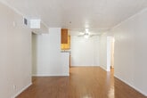 Located at 2100 S Lewis St in Anaheim, California, this single-story unit offers a straightforward, functional layout suitable for everyday living. The main living area is generously proportioned, featuring warm hardwood-style flooring that extends throughout the common spaces. A ceiling fan provides both light and airflow, while a sliding glass door and adjacent window allow natural light to filter in and provide access to the outdoors. The open design connects the living space fluidly to the kitchen area.

The galley-style kitchen is equipped with warm honey-toned wood cabinetry extending to the upper walls, granite-patterned countertops, a gas range, a dishwasher, and a double sink — offering ample storage and functional workspace. The layout promotes an efficient flow between cooking and dining areas.

The bedrooms are carpeted for comfort, each featuring vertical blind-covered windows that bring in natural light and views of surrounding greenery. One bedroom includes a mirrored sliding-door closet, providing practical storage. The bathroom is finished with a single-sink vanity topped with granite-patterned counters, white cabinetry, and a tub-shower combination, maintaining a clean and cohesive aesthetic throughout the unit.