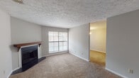 Located at 1647 London Town Ln in Montgomery, Alabama, this single-floor residence offers a practical and well-organized layout across several distinct living areas. The living room serves as the central gathering space, featuring plush carpeting, a classic fireplace with a wood mantle, and a large multi-pane window that draws in natural light. A textured ceiling adds character throughout the common areas. Adjacent to the living room, a separate room with its own chandelier and a glass-paneled door provides flexible use as a dining room or additional living space. The kitchen is thoughtfully designed with crisp white shaker-style cabinetry, light stone-look countertops, a black electric range with overhead ventilation, a double-basin sink, and durable wood-look flooring that ties the space together. The bedrooms continue the carpeted aesthetic, offering comfortable and quiet retreats with neutral wall tones and ample natural light from windows with blinds. The bathroom includes a vanity with a stone-look countertop, a large mirror, wood-look flooring, and a full tub-shower combination with white tile surround. Clean lines and neutral finishes throughout give this residence a move-in-ready appeal.