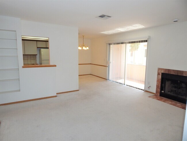 Living room looking towards the dining room with gas fireplace and balcony - 1341 Del Mar St