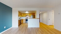 Located at 20123 Lorain Rd in Fairview Park, Ohio, this single-floor unit offers a well-organized layout with consistent light hardwood flooring that runs throughout the living areas, bedrooms, and hallways, creating a warm and cohesive feel across the space.

The kitchen is a standout feature, showcasing warm honey-toned wood cabinetry with modern black hardware, crisp white quartz countertops, and a classic white subway tile backsplash. Stainless steel appliances — including a range, dishwasher, and refrigerator — complete the functional and updated cooking space. The kitchen opens to the living area via a half-wall pass-through, enhancing the sense of openness and flow between rooms.

The living area is generously proportioned, featuring large windows with vertical blinds that allow natural light to fill the room. A bold teal accent wall adds a pop of color and visual interest to the space. Baseboard heating and a wall-mounted AC unit provide year-round comfort.

The bedrooms are well-sized and bright, each offering closet space, including one with a dedicated walk-in style closet with built-in shelving. One bedroom features a private ensuite bathroom, while the main bathroom includes mosaic tile flooring, a tub/shower combination, and a vanity with a white countertop. The overall ambiance is clean, updated, and move-in ready.