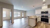 Located at 22 Washington Ave in Sandy Hook, Connecticut, this single-floor unit offers a thoughtfully designed open-concept layout finished with contemporary details throughout. The kitchen serves as a central hub of the space, featuring white shaker-style cabinetry, a classic subway tile backsplash, neutral-toned countertops, and a full suite of stainless steel appliances including a range, over-the-range microwave, dishwasher, and refrigerator. A peninsula with an integrated sink provides both additional workspace and a natural divide between the kitchen and the living area. The living space is generously proportioned, benefiting from recessed lighting, track lighting accents, and a door providing direct outdoor access, allowing natural light to flow freely throughout. Durable wood-look flooring runs consistently through the main living areas, lending warmth and visual continuity. Multiple additional rooms offer versatile use, each featuring neutral wall tones, wood-look flooring, and windows that bring in ample natural light. The bathroom is clean and efficiently designed, with a dark-toned vanity, white countertop, tiled shower, and light flooring. The overall aesthetic is modern, clean, and move-in ready, making it a practical and attractive space in the Sandy Hook community.