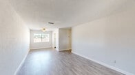 Located at 640 Northern Rd in South Daytona, Florida, this single-story, 2-bedroom, 1-bathroom home offers a clean and functional layout with modern finishes throughout. The combined living and dining area is bright and welcoming, featuring light gray wood-look flooring, a ceiling fan, textured ceilings, and a window that allows natural light to fill the space. The front entry area mirrors the same flooring and neutral palette, creating a cohesive flow through the main living spaces. The kitchen is well-appointed with white shaker-style cabinetry, light granite-look countertops, a white subway tile backsplash, a stainless steel sink, and black appliances including a refrigerator and range. Both bedrooms are carpeted and feature closets—one with a double sliding-door closet—and windows with views of the surrounding neighborhood. The full bathroom includes a tub-shower combination with white tile surround, a vanity with gray cabinetry, and wood-look flooring. Additional features include multiple closets for ample storage, a utility room, and a hallway connecting the private areas of the home. The neutral color scheme and updated finishes give the space a clean, move-in ready appeal.