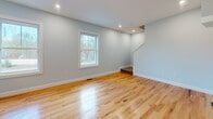 This three-story residence in South Bernice, ME, offers a generous 1530 square feet of living space. The home boasts five bedrooms and three bathrooms, providing ample room for a growing family or those who enjoy hosting guests. The primary bedroom is a comfortable 170 square feet, ensuring a spacious retreat for the homeowners.

The interior is characterized by its bright, airy feel, with large windows in most rooms offering picturesque views of the surrounding forest. Hardwood floors feature prominently throughout, adding warmth and character to the space. The modern kitchen is a highlight, featuring sleek white cabinetry, stainless steel appliances, and a practical island that doubles as a breakfast bar.

Bathrooms are well-appointed with contemporary fixtures, including a walk-in shower with built-in shelving. The home's multiple living areas provide versatile spaces for relaxation and entertainment. A garage offers convenient parking and additional storage space, while the unfinished basement presents potential for customization or extra storage.

The property's layout, spread across three floors, allows for excellent separation of living spaces. With its combination of modern amenities, ample natural light, and forest views, this home presents an attractive option for those seeking a serene yet practical living environment in Maine.