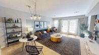This 630 square foot, single-floor apartment in West Deptford, NJ, offers a thoughtfully designed living space. The one-bedroom layout is complemented by two bathrooms, providing convenience and privacy. The living room serves as the heart of the home, featuring a contemporary aesthetic with a gray sofa, wooden coffee table, and a striking world map wall decoration. The kitchen, while compact, is well-equipped with wooden cabinetry and white appliances. The bedroom, spanning 180 square feet, boasts a serene ambiance with a blue accent wall and modern furnishings. Throughout the apartment, a cohesive color scheme of blues, grays, and warm woods creates a harmonious atmosphere. The bathrooms are sleek and functional, with one featuring hanging plants for a touch of greenery. Large windows in the living area allow for ample natural light, enhancing the sense of space. Despite its modest size, the apartment's clever design and stylish decor make it feel both spacious and inviting.