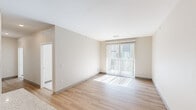 This thoughtfully designed 2-bedroom, 2-bathroom unit offers a clean, modern aesthetic throughout its single-floor layout. The open-concept kitchen and living area serves as the heart of the space, where light wood-style flooring extends seamlessly underfoot. The kitchen is well-appointed with white shaker cabinetry, granite-look countertops, stainless steel appliances including a refrigerator, electric range, over-the-range microwave, and dishwasher, plus a center island that provides additional prep and dining space.

The living room is bright and airy, benefiting from large sliding glass doors dressed with vertical blinds that invite natural light and provide outdoor access. Both bedrooms feature plush carpeting and neutral wall tones, creating a calm and comfortable retreat. The primary bedroom offers a generous footprint with its own dedicated access to one of the two bathrooms.

Both bathrooms are finished consistently with wood-style flooring, granite-look vanity countertops, and tub-shower combinations. One bathroom features a darker, gray-toned vanity cabinet, while the other is finished in lighter tones, offering a subtle distinction between the two. The overall palette throughout the unit is neutral and contemporary, making the space feel bright, cohesive, and move-in ready.