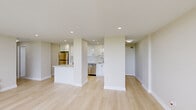 Located at 150 Allan St, Suite 803 in Oakville, Ontario, this thoughtfully designed unit offers a clean, contemporary aesthetic with light hardwood flooring flowing seamlessly throughout every room. The open-concept kitchen is a standout feature, appointed with sleek high-gloss white cabinetry extending to the ceiling, a white quartz peninsula, and a full suite of stainless steel appliances including a refrigerator, electric range, built-in microwave, and dishwasher. A stacked in-unit washer and dryer adds further convenience. The spacious living area is bathed in natural light through floor-to-ceiling windows and a sliding glass door that opens directly onto a private balcony, offering sweeping views of the surrounding tree canopy and Oakville skyline. The bedrooms are well-proportioned, each featuring large windows that bring in ample daylight, baseboard heating, and neutral warm tones. One bedroom includes a generous built-in closet with sliding doors and integrated shelving. Throughout the unit, the clean white walls, recessed lighting, and minimalist design details create a bright and airy ambiance well-suited for comfortable urban living in the heart of Oakville.