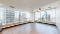 Located in the heart of downtown Dallas, this sophisticated 2-bedroom, 4-bathroom residence offers a seamless blend of modern design and urban convenience. Rich hardwood flooring flows throughout the open-plan living and kitchen area, where floor-to-ceiling windows frame stunning panoramic views of the Dallas skyline, flooding the space with natural light. The gourmet kitchen is outfitted with sleek grey cabinetry, white quartz countertops, a textured diamond-pattern tile backsplash, premium stainless steel appliances, and a built-in wine cooler — ideal for both everyday living and entertaining. The spacious primary bedroom continues the floor-to-ceiling window theme, offering breathtaking city views and generous proportions. Its en-suite bathroom features a dual-sink vanity with dark wood cabinetry, gold-accented framing, and large-format porcelain tile flooring. Both walk-in closets provide ample built-in shelving and hanging space. The additional bedrooms and bathrooms maintain the same refined aesthetic, with clean lines and neutral tones throughout. A dedicated laundry room with an in-unit washer adds everyday convenience. Every detail of this residence reflects thoughtful, high-quality design in one of Dallas's most vibrant urban locations.