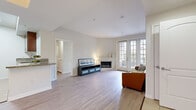 Located at 11950 Idaho Ave in the desirable West Los Angeles neighborhood of Los Angeles, CA, this 2-bedroom, 4-bathroom unit offers a thoughtfully designed single-level layout. The open living room is a welcoming centerpiece, featuring light wood flooring, a corner fireplace, and a set of French doors that invite natural light and provide access to an outdoor patio area. The kitchen is well-equipped with rich dark wood cabinetry, stainless steel appliances including a gas range, microwave, refrigerator, and dishwasher, complemented by granite countertops and light tile flooring. A breakfast bar adds convenient counter seating. The two bedrooms feature the same light wood flooring as the main living area, with clean neutral walls and ample closet space, including sliding glass-panel closet doors. The four bathrooms are finished with granite-topped wood vanities, tile flooring, and glass-enclosed showers with tile surrounds, reflecting a consistent and polished design aesthetic. A hallway and dedicated closet round out the floor plan. The overall ambiance is clean, modern, and bright, with a neutral color palette that creates a calm and versatile living environment throughout the space.
