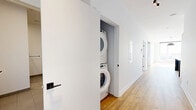 Located at 3555 Rue Saint-Antoine O in Montreal, this well-appointed one-bedroom, one-bathroom unit offers a thoughtfully designed layout across a generous single floor. Warm-toned hardwood flooring flows throughout, complementing the bright white walls and clean modern aesthetic visible in every room. The open-concept kitchen and living area serves as the heart of the space, featuring a striking two-tone kitchen with matte navy and light wood cabinetry, a large central island with a white quartz countertop, stainless steel appliances, a bold range hood, and a white subway tile backsplash — an ideal setup for both cooking and entertaining. The living area is bathed in natural light, with access to a private balcony that brings in additional brightness. The bedroom is a calm, well-proportioned retreat with a built-in closet and ample natural light. A versatile den provides flexible space for a home office or guest area. The bathroom is finished to a high standard, featuring large-format floor tiles, a floating wood-grain vanity, an integrated white sink, a round black-framed mirror, and a soaking tub. A dedicated laundry closet with stacked washer and dryer adds everyday convenience. Two additional closets and a hallway complete the practical, well-organized floor plan.