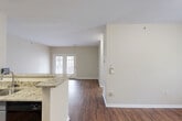 This well-appointed 2-bedroom, 2-bathroom single-floor home in Chattanooga, TN offers a practical and comfortable layout designed for easy living. The open-concept main area seamlessly connects the kitchen and living room, creating a welcoming and functional shared space. The kitchen is equipped with granite countertops, gray cabinetry, black appliances, and a peninsula that opens to the living area — ideal for both cooking and entertaining. Rich hardwood-style flooring flows throughout the main living spaces, adding warmth and cohesion to the interior.

The living room is bright and airy, highlighted by French doors that invite natural light and provide direct access to the outdoors. Neutral-toned walls throughout the home create a clean, versatile backdrop. Both bedrooms feature plush carpeting and ceiling fans, with the primary bedroom offering a generous footprint, a walk-in closet, and direct access to a full bathroom complete with a granite vanity and gray cabinetry. The second bedroom is carpeted with a large window overlooking the surrounding greenery. A second full bathroom includes a tub/shower combination with clean white tile. Each bedroom also features dedicated closet space for ample storage.