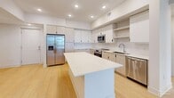 Located at 9030 SW 158th Ave in Miami, FL, this well-appointed single-story home offers four bedrooms, two bathrooms, and a thoughtfully designed open floor plan. Light wood-style flooring flows seamlessly throughout every room, creating a cohesive and airy atmosphere.

The modern kitchen is a standout feature, equipped with stainless steel appliances including a refrigerator with ice maker, microwave, range, and dishwasher. Sleek two-tone cabinetry, a subway tile backsplash, and a generous center island with a crisp white countertop provide ample workspace and storage. Recessed lighting illuminates the kitchen and connects it naturally to the adjoining dining and living areas, where a ceiling fan adds comfort.

The four bedrooms are bright and well-proportioned, with large windows that frame views of the surrounding South Florida landscape, including glimpses of palm trees. The spacious primary bedroom offers a comfortable retreat. Four closets are distributed throughout the home to ensure practical storage.

Both bathrooms are finished with clean, modern fixtures. One features a full tub-shower combination with white subway tile surround, an extended vanity with white countertop, and wood-tone cabinetry. The second bathroom includes a window for natural light and a tiled shower area.

Additional spaces include a dedicated laundry room, a utility room, and a balcony, rounding out this functional and contemporary Miami home.
