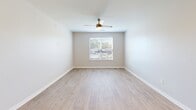 Located at 100 Fair Oaks Dr in Savannah, GA, this single-story, 3-bedroom, 2-bathroom home offers a well-designed open floor plan with modern finishes throughout. The kitchen serves as the centerpiece of the main living area, featuring crisp white shaker cabinetry, quartz countertops, a subway tile backsplash, a central island, stainless steel appliances — including a dishwasher, range, microwave, and refrigerator — and light-toned luxury vinyl plank flooring that extends seamlessly into the living room. The living room is bright and open, with recessed lighting and a ceiling fan, allowing natural light to fill the space through a large window. The three bedrooms are carpeted and equipped with ceiling fans, offering a comfortable and quiet retreat. The generously sized primary bedroom provides ample space for a full furniture arrangement. The two bathrooms are finished with wood-look LVP flooring, white vanities with brushed nickel hardware, and white subway tile surrounds — one featuring a walk-in shower and the other a shower-tub combo. A dedicated closet adds practical storage. Neutral paint tones and clean lines throughout give the home a fresh, move-in-ready feel.