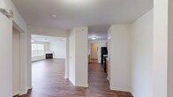 Located at 6690 Hauser Rd in Macungie, PA, this well-appointed 2-bedroom, 2-bathroom single-floor residence offers a thoughtfully designed layout across a generous living footprint. Rich hardwood-style flooring flows throughout, lending warmth and visual continuity to the space.

The open-concept living area impresses with vaulted ceilings and a stylish pendant chandelier, creating an airy, elevated atmosphere. A gas fireplace serves as a focal point, while a ceiling fan and large windows invite natural light. Sliding doors lead to a private balcony overlooking a lushly landscaped community with mature trees.

The kitchen features warm wood cabinetry, a breakfast bar peninsula, black appliances including a refrigerator and range, and ample counter space — all open to the main living area for easy interaction.

The generously sized primary bedroom includes a large closet and connects to a well-appointed en-suite bathroom complete with dual vanities featuring granite-style countertops, warm wood cabinetry, and a corner soaking tub with tile surround. The second bedroom is bright and spacious with its own closet.

Additional highlights include four closets for abundant storage, a dedicated laundry area, two hallways, and a welcoming entrance. The layout is practical, functional, and move-in ready.