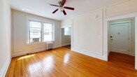 Located in the desirable Northwest Washington neighborhood of 3621 Newark St NW, this single-floor residence blends classic architectural charm with functional updates. Warm-toned hardwood floors run throughout the living areas and bedrooms, lending a cohesive and timeless aesthetic to the entire space.

The living area is generously proportioned, featuring elegant wall paneling details, a ceiling fan, and large windows that invite abundant natural light. Classic cast-iron radiators provide reliable warmth, while window-mounted AC units ensure year-round comfort.

The kitchen is well-appointed with rich cherry-toned cabinetry, dark granite countertops, and stainless steel appliances including a full-size refrigerator and a gas range, making it an efficient and attractive workspace. Crown molding adds a refined finishing touch overhead.

The bedrooms continue the home's warm character, each offering hardwood floors, ceiling fans, ample natural light through well-sized windows, and classic millwork detailing on the walls. The bathroom features light tile flooring, a rich wood vanity, a full soaking tub with shower, and a window for natural ventilation — all presented in a clean, neutral palette. This residence offers a well-balanced combination of traditional DC architecture and practical modern amenities.