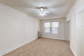 Located at 4606 N Hermitage Ave in Chicago's charming Ravenswood neighborhood, this one-bedroom, one-bathroom unit offers a well-designed layout with classic architectural character throughout. The generously sized bedroom is the heart of the space, featuring elegant wainscoting-style wall paneling, soft wall-to-wall carpeting, a ceiling fan with integrated lighting, a traditional cast-iron radiator, and a mirrored sliding closet. Natural light filters in through a street-facing window, brightening the neutral, cream-toned interior. Three closets provide ample storage throughout the unit. The bathroom showcases vintage charm with a classic clawfoot soaking tub, a curved shower rod, white subway tile walls, a basketweave tile floor, a pedestal-style vanity with mirror, and a window for natural ventilation. The compact kitchen is efficiently arranged with white cabinetry, a gas range, a stainless steel sink, and laminate countertops. A textured ceiling and clean white trim are consistent throughout, lending a cohesive, timeless aesthetic. The overall ambiance is bright, understated, and functional — ideal for those seeking a characterful yet practical home in a well-established Chicago neighborhood.
