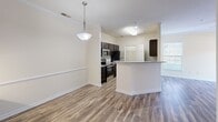 This 650 square foot single-floor apartment in Glen Allen, Virginia, offers a blend of modern amenities and efficient design. The heart of the home is a contemporary kitchen featuring dark wood cabinetry, granite countertops, and stainless steel appliances. A breakfast bar with pendant lighting separates the kitchen from the living area, enhancing the open-concept feel.

The main living space boasts wood-look flooring, creating a warm and inviting atmosphere. The generous 220 square foot bedroom provides ample space and includes plush carpeting for comfort. A large window in the bedroom allows natural light to flood the space, while a ceiling fan ensures good air circulation.

The bathroom, though not pictured, likely continues the modern aesthetic found throughout the apartment. The overall design prioritizes functionality without sacrificing style, making excellent use of the available 650 square feet. This apartment is ideal for singles or couples seeking a well-appointed living space in a convenient location.