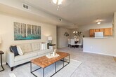Located at 1 Ashbury Woods Dr in Huntsville, Alabama, this single-floor residence offers a thoughtfully designed layout across a generous footprint. The open-concept living room is a standout feature, showcasing plush carpeting, a ceiling fan, and expansive sliding glass doors that flood the space with natural light and provide direct access to a private patio overlooking lush greenery. The adjacent dining area is defined by an elegant chandelier, creating an intimate setting ideal for everyday meals or entertaining. The kitchen features warm oak cabinetry, ample counter space, and white appliances including a refrigerator, electric range, and built-in microwave, all set on easy-to-maintain hardwood-style flooring. The residence includes multiple well-proportioned bedrooms, each finished with soft carpeting and ceiling fans. The bedrooms offer closet storage—including sliding-door closets—and windows dressed with blinds and curtains that allow for natural light while maintaining privacy. The bathrooms are finished with tile flooring and include shower/tub combinations. Neutral, warm-toned walls throughout the home provide a clean, cohesive aesthetic that complements a variety of décor styles. This residence combines comfortable living spaces with practical features in a serene Huntsville setting.